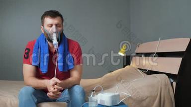 人用<strong>雾化</strong>器吸入. 年轻人独自坐在房间里，脸上戴着吸入面罩